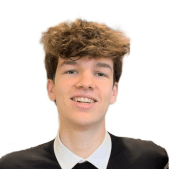 Jeune homme aux cheveux bruns bouclés, souriant légèrement et regardant devant lui, sur fond blanc uni.